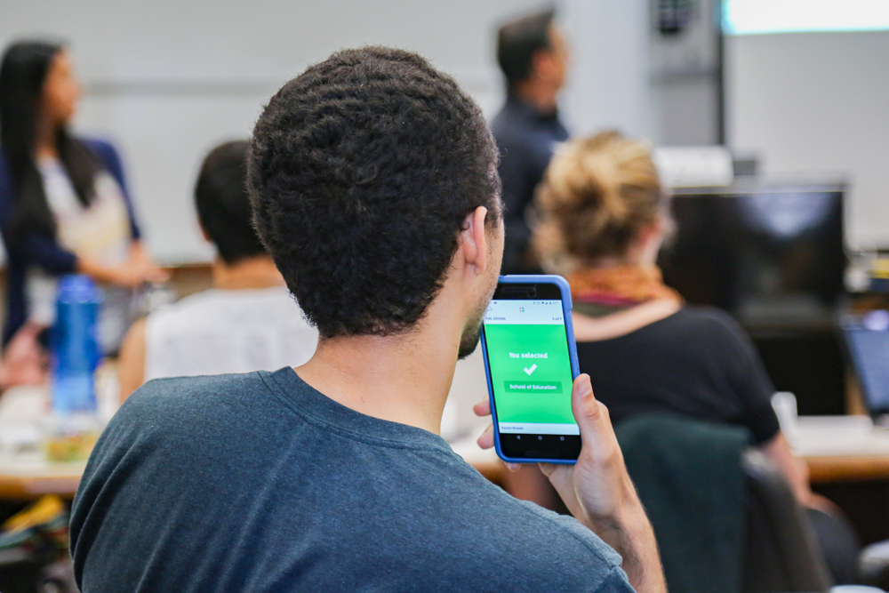Student participating in class with his smart phone