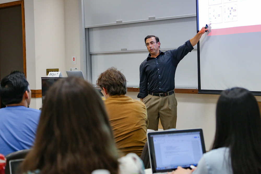 Sergio Monsalve giving a lecture in front of a projector